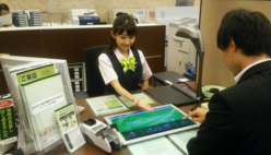 (写真)支店のブースで、タッチパネル式のSMBCステーションを使ってお客さまと相談する三井住友銀行の従業員