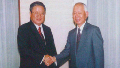 Hiroki Jinnai, President of Promise (left), and Yoshifumi Nishikawa, President of SMFG (right), shake hands at the signing ceremony for the partnership agreement (June 2004)